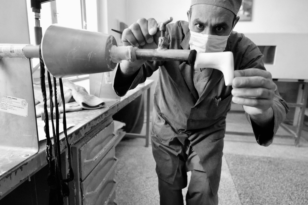 Ein Orthopäde arbeitet konzentriert am Fußteil einer Beinprothese.