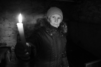 Valentina hält in einem Keller eine Kerze hoch.