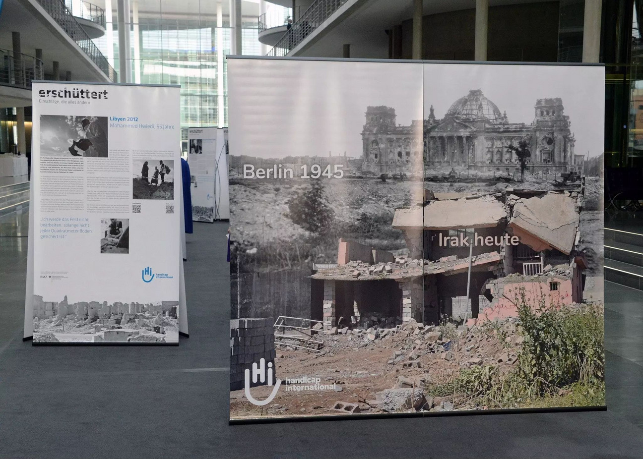 Auf dem Roll-Up liegen der Reichtsag und ein Gebäude im Irak in Trümmern.